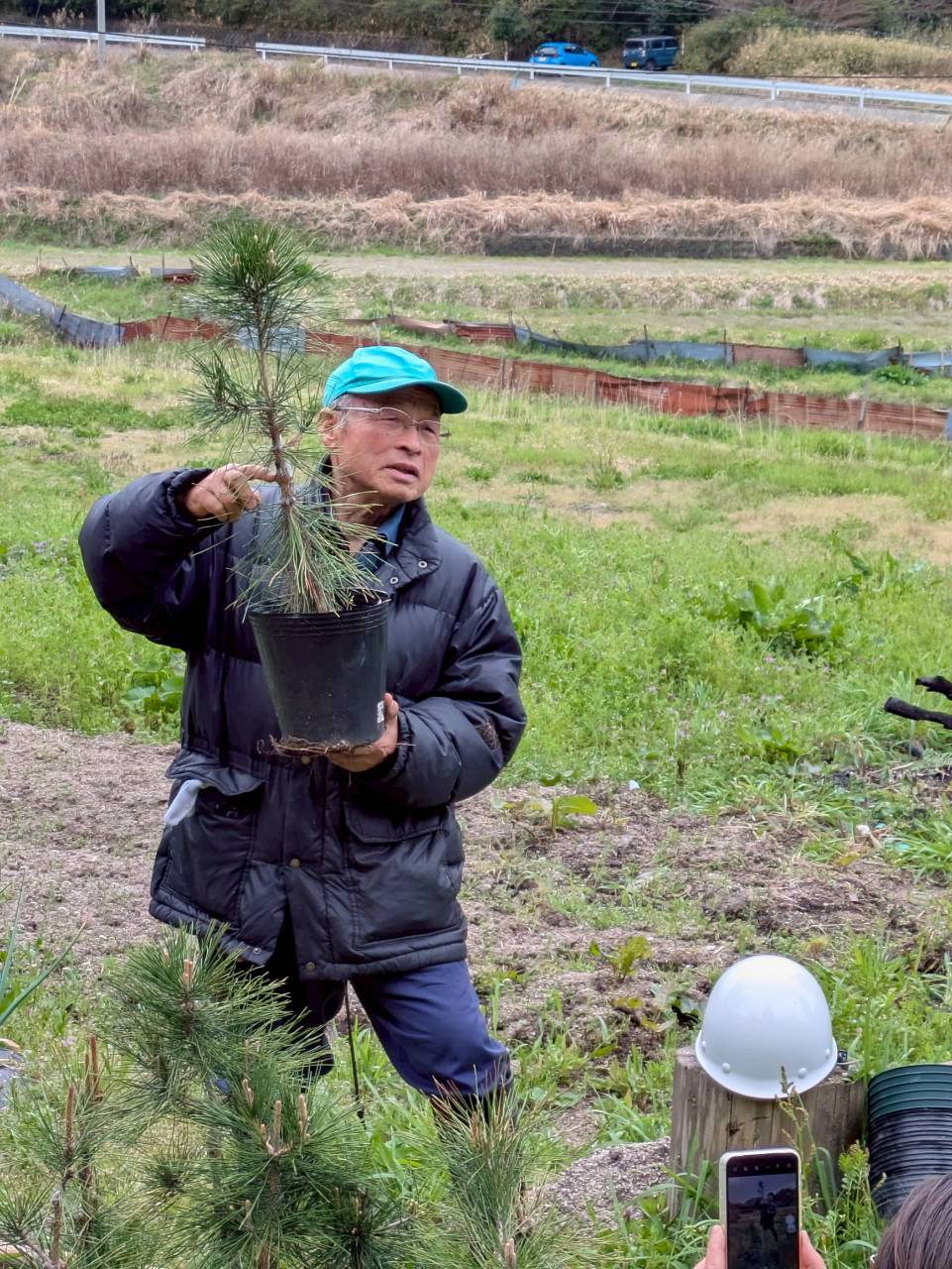 接ぎ木した苗をもち説明する様子
